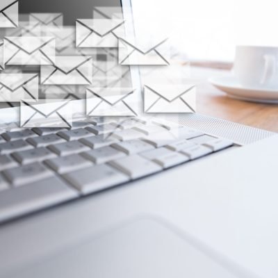 Sobres de correo saliendo de un teclado en una campaña de email marketing